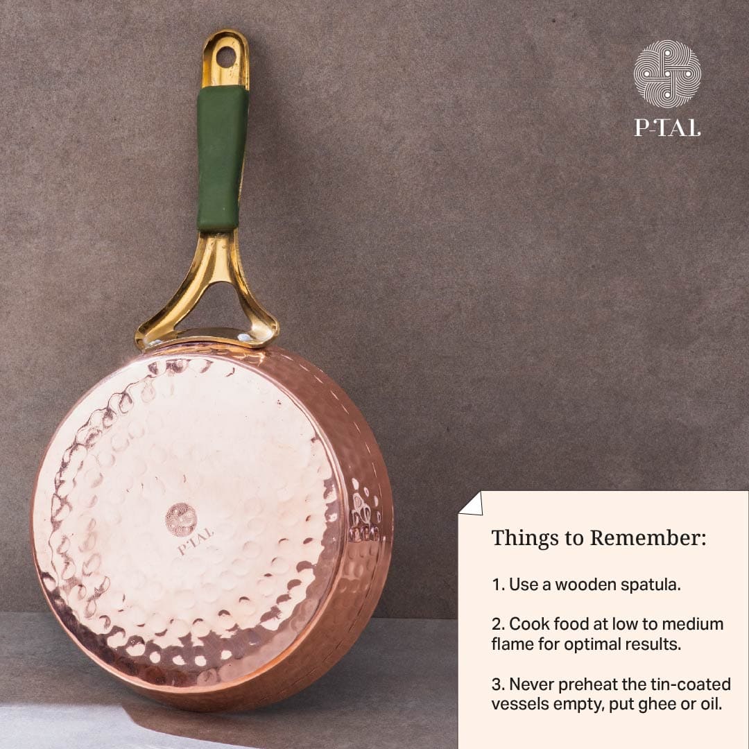 Copper frypan showing its hammered bottom, brass handle with green grip, and care instructions card. P-TAL brand logo.