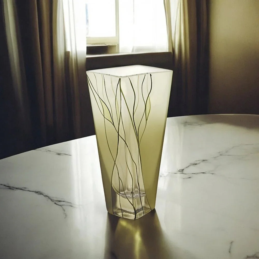 Frosted square glass vase with wavy line design on a marble table by a window