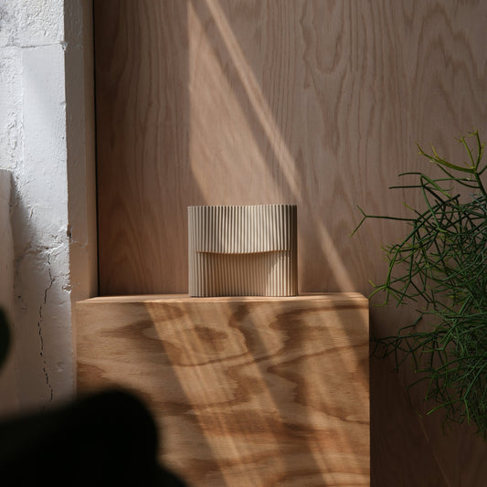 Corduroy stoneware table lamp styled on a wood block with natural light and greenery