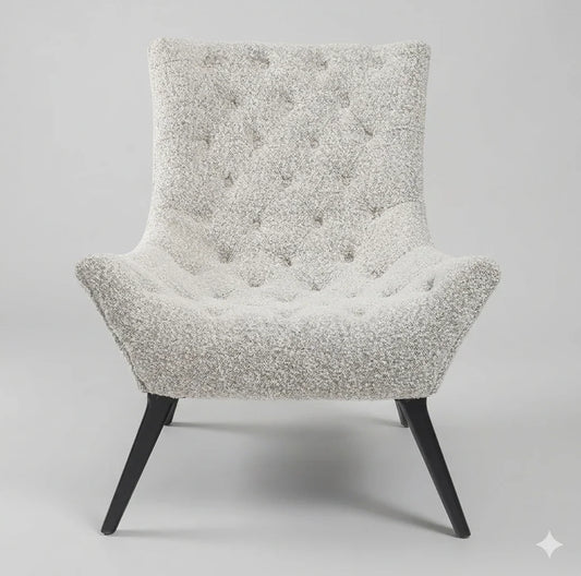 Front studio view of the gray tufted boucle lounge chair, highlighting its high backrest, deep tufting, and splayed black wood legs against a soft, light gray background.