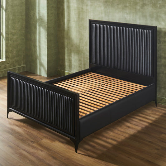 A black genuine leather quilted bed frame shown at an angle with wooden slat support visible, stripe quilting on panel headboard and footboard, iron legs, on hardwood floor with green wall backdrop. 🌿
