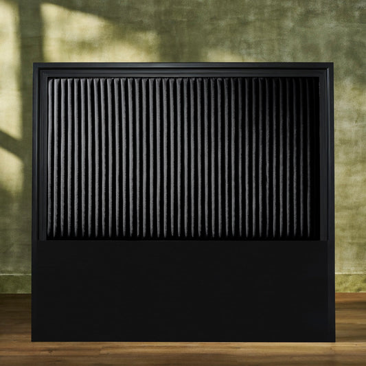 Stanford Genuine Leather Ribbed Headboard in all-black with matte frame and vertical ribbed leather panel styled against an earthy green wall