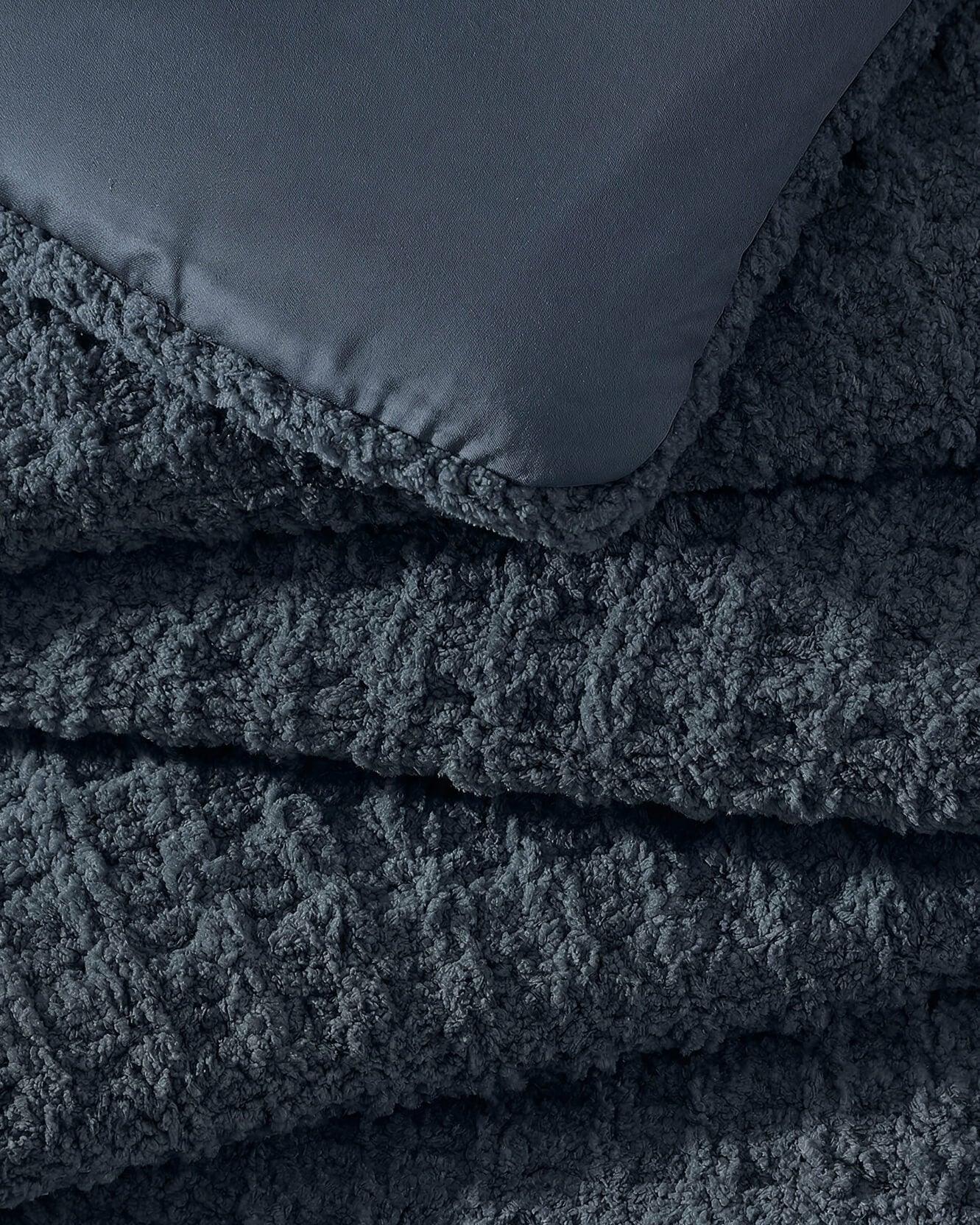 Close-up of Midnight navy Snug fabric texture showing deep navy plush waffle knit weave detail with smooth bamboo viscose reverse side contrast