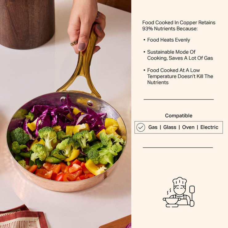 Copper frypan with brass handle, filled with colorful chopped vegetables like broccoli, bell peppers, and cabbage.