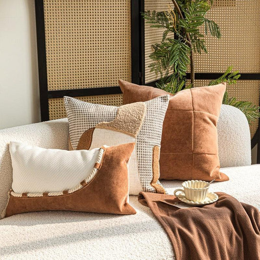 Wabi-sabi throw pillows in caramel and off-white cotton-linen styled on a modern sofa with rattan backdrop