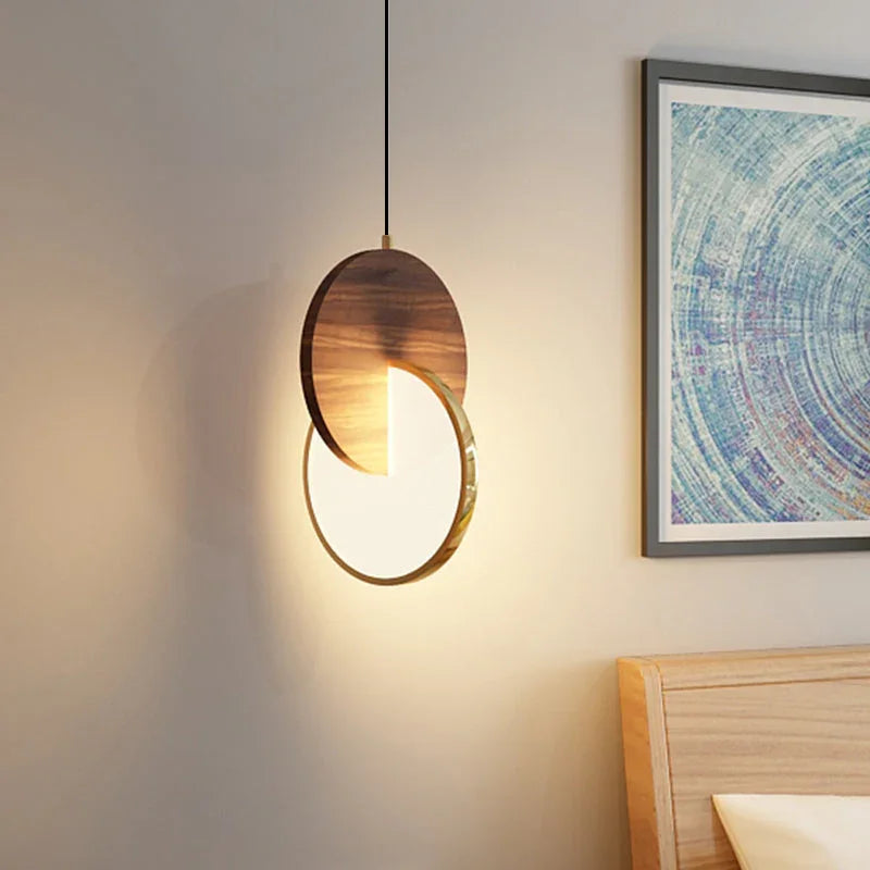 Modern wooden pendant light with illuminated disc and warm walnut finish