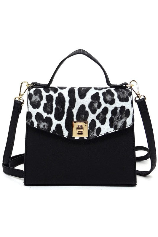 Black handbag with white and black leopard print flap, top handle, gold clasp, and detachable shoulder strap