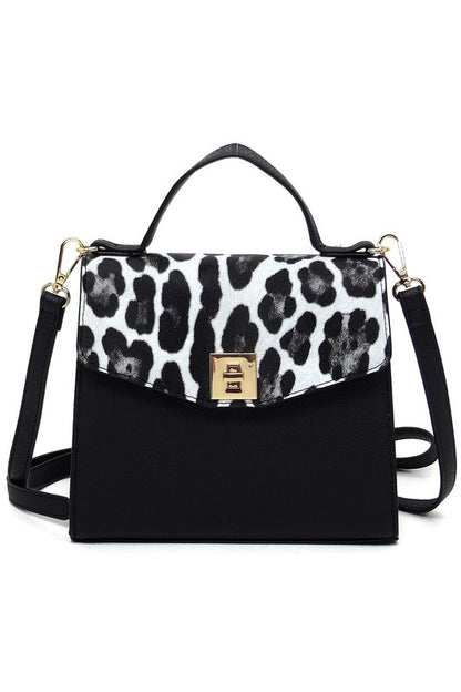 Black handbag with white and black leopard print flap, top handle, gold clasp, and detachable shoulder strap