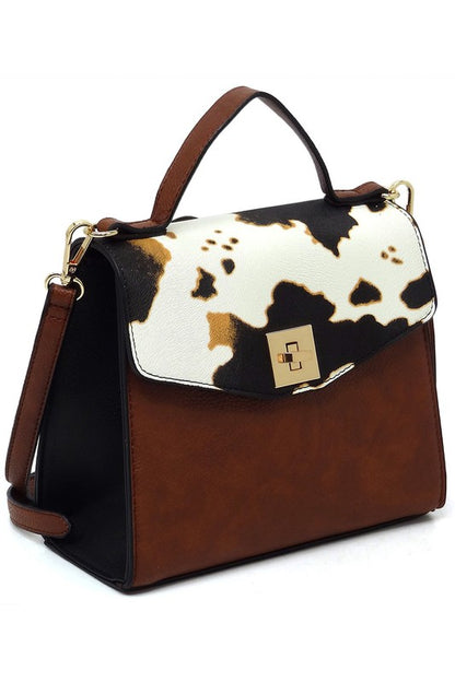 Brown leather handbag with cow print flap and gold-tone clasp, top handle and shoulder strap