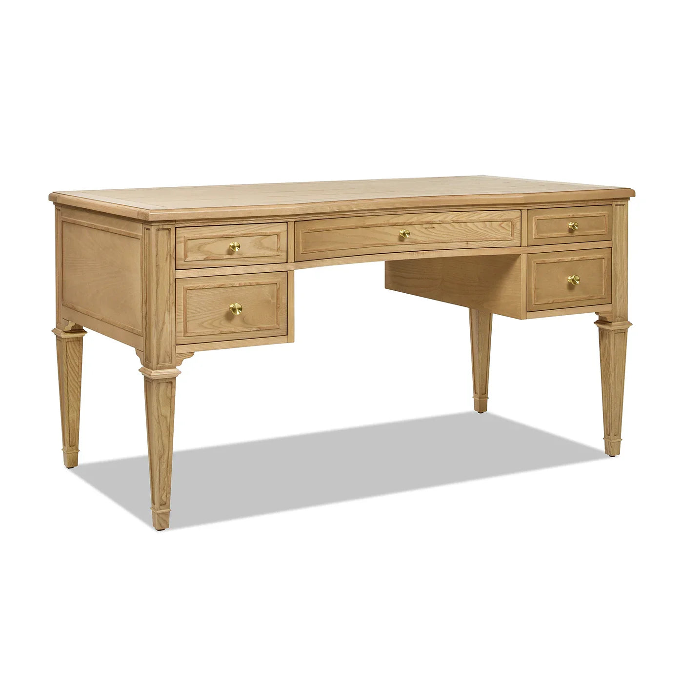 Three-quarter perspective of an ash wood executive desk showing the depth, wood grain texture, and elegant satin-gold accents.