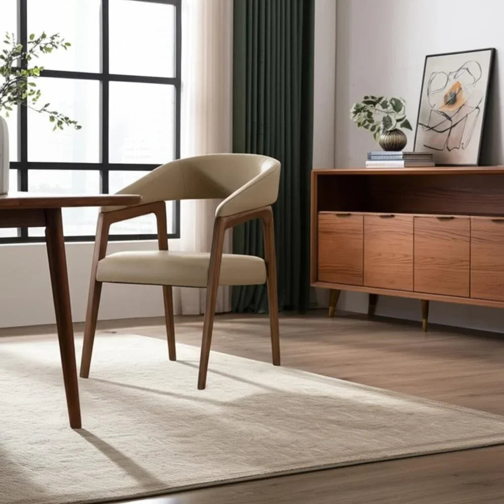 Modern beige upholstered chair with wooden legs in stylish living room next to wooden sideboard and large window