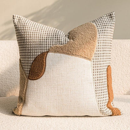 Close-up of wabi-sabi cotton-linen pillow cover with waffle-weave texture and caramel appliqué patchwork detail