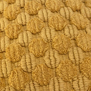 Close-up of textured yellow wool fabric with raised circular patterns, home decor textile
