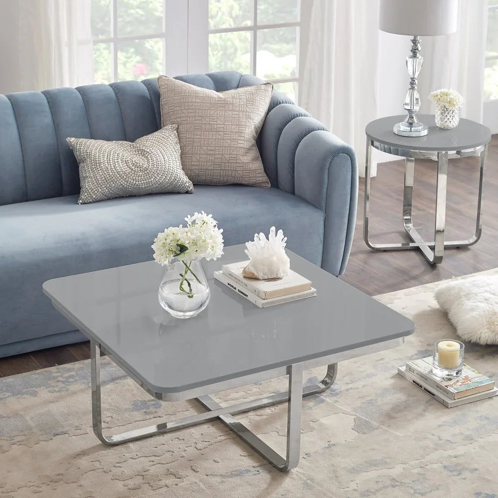 Modern living room with blue velvet sofa, gray coffee table, side table, and decorative pillows