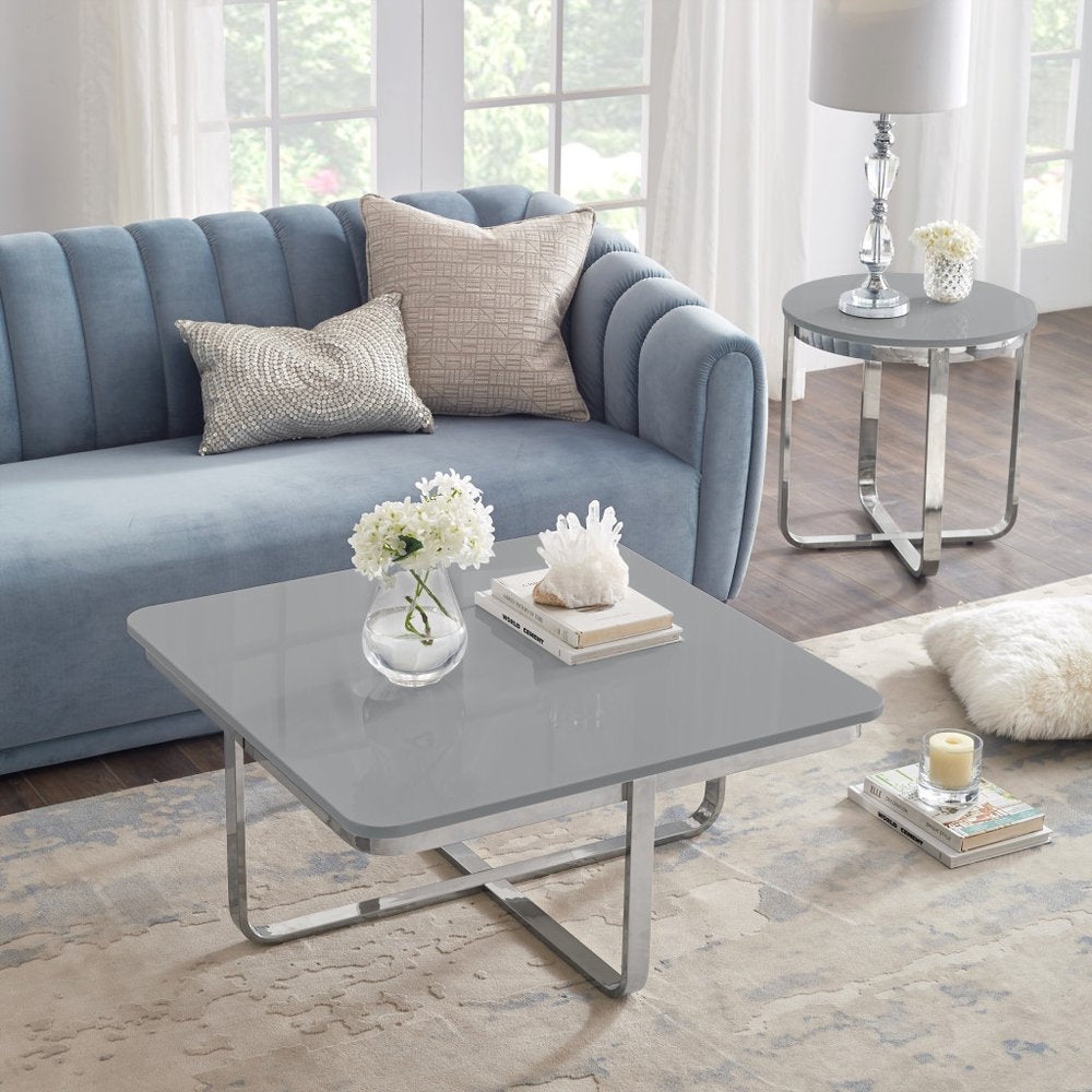 Modern living room with blue velvet sofa, grey coffee table, and decorative accents
