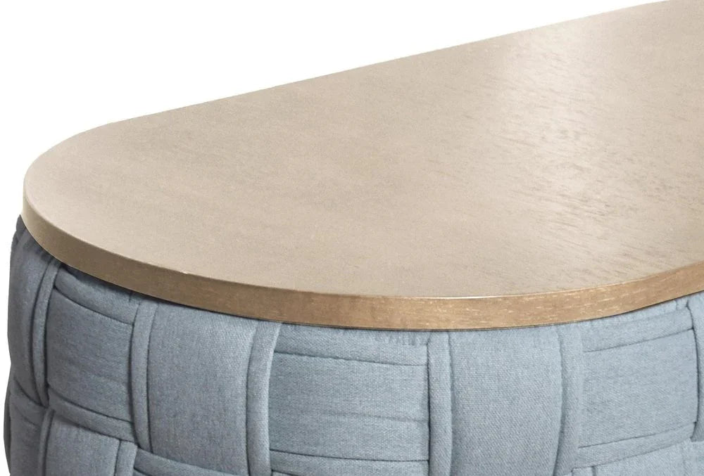 A high-resolution close-up showcasing the smooth, light oak finish of the Kinsley oval woven ottoman table top.