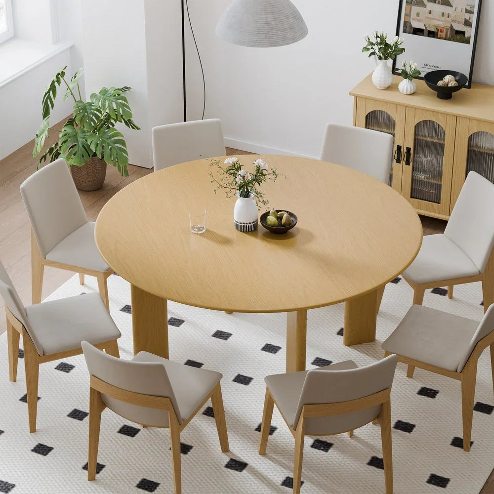 Modern round wooden dining table with six beige chairs in a stylish home interior, Fluent Trends