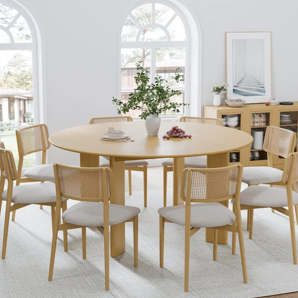 Modern light wood dining set with round table and six chairs in bright, minimalist room
