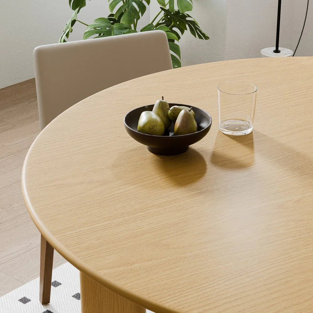 Modern light wood dining table with pears in a bowl, glass, chair and plant, Fluent Trends