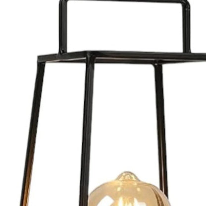 Studio shot of a cordless geometric metal lantern featuring a black pyramid-style frame and a warm illuminated Edison bulb against a white background.