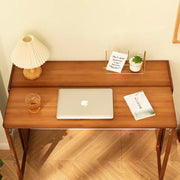 Bamboo folding desk in a home office with a laptop, drink, and small plant on top, showcasing its functionality