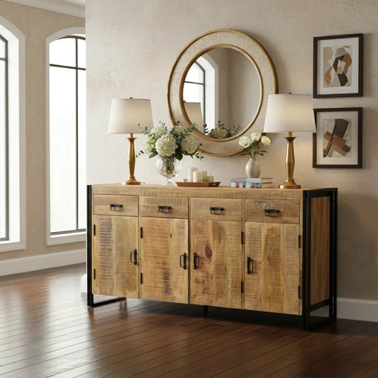 Modern living room with rustic wood sideboard, gold lamps, round mirror, and floral decor