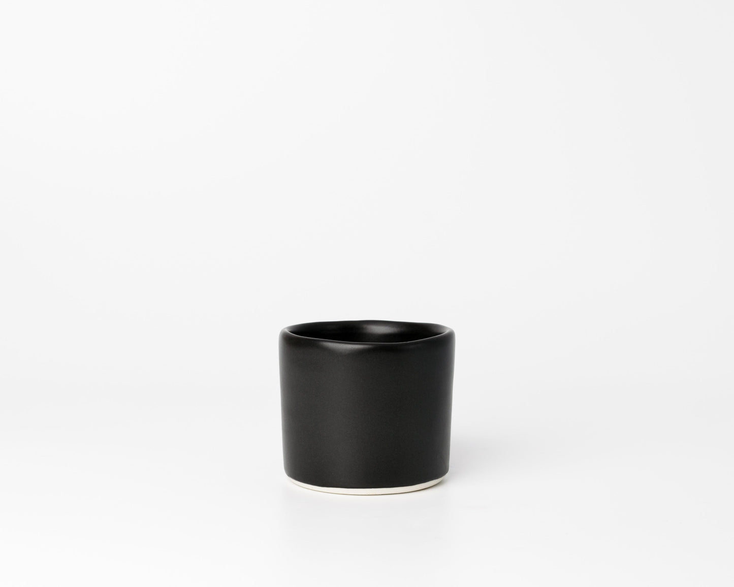 Minimalist black ceramic cup with a smooth matte finish on a white background
