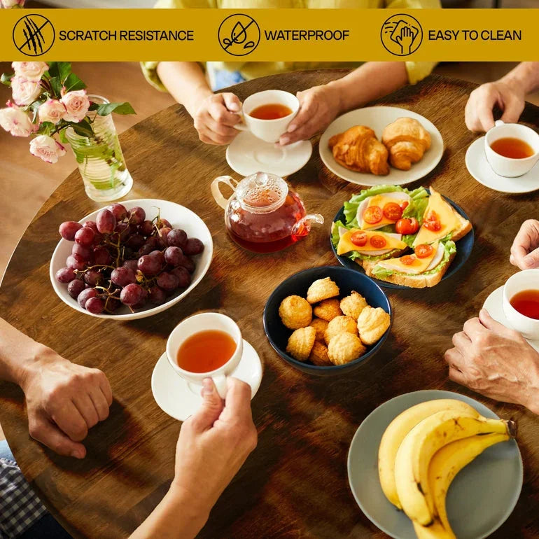 Wooden dining table with tea cups, fresh fruit, croissants, savory toast, and cookies showcasing scratch-resistant, waterproof, and easy-to-clean surface