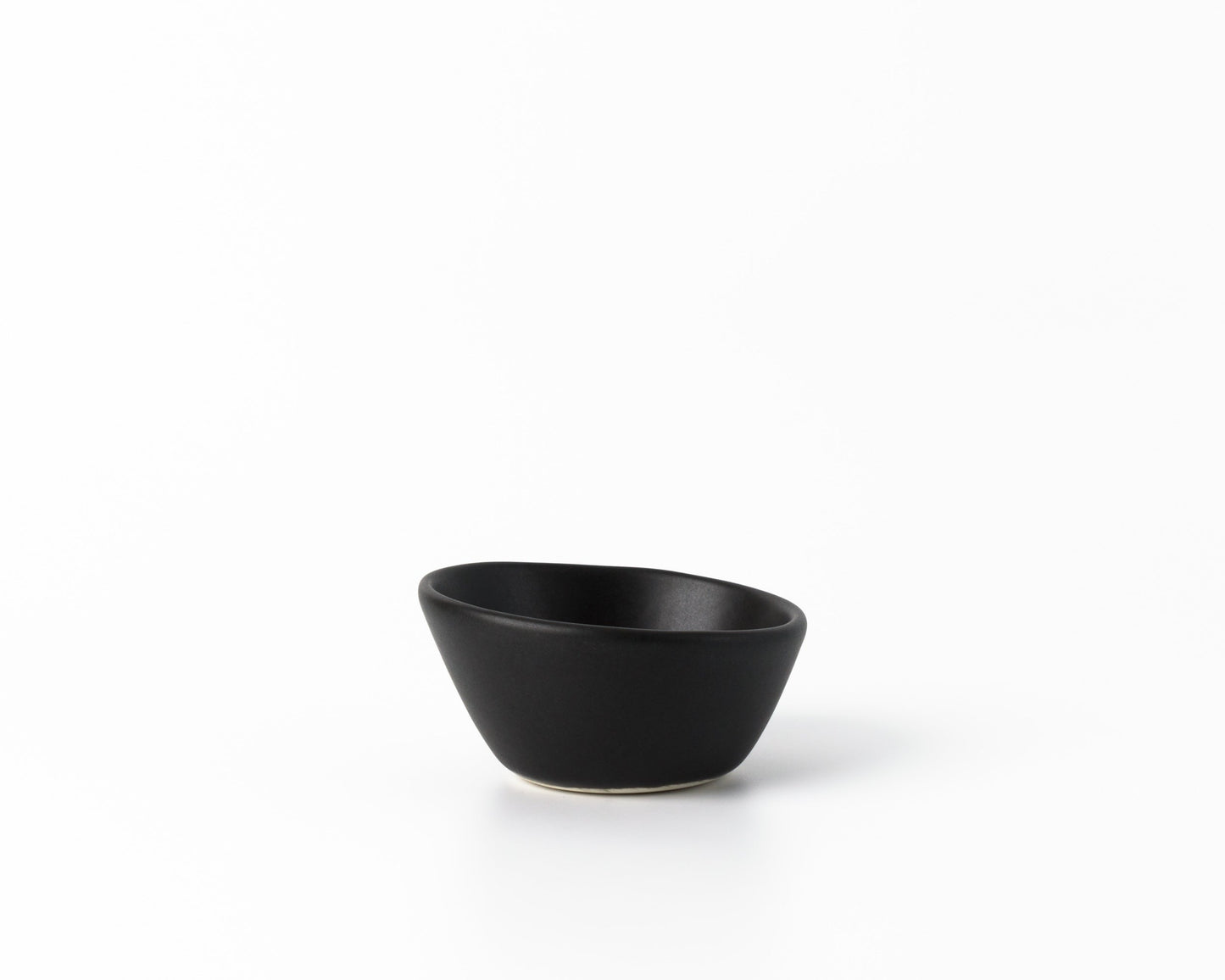 Small black ceramic dessert bowl with an organic, asymmetrical shape on white background