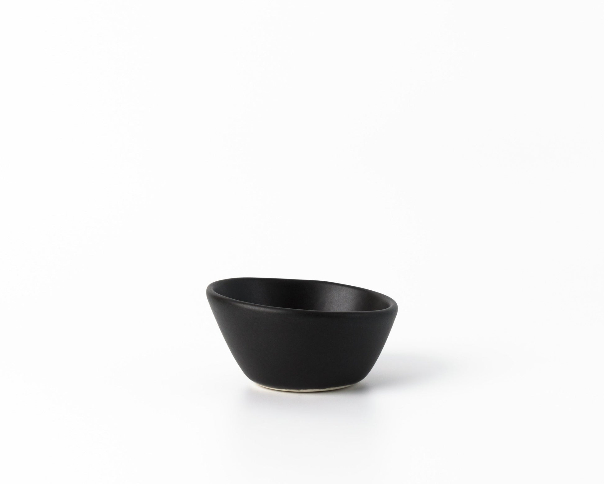 Small black ceramic dessert bowl with an organic, asymmetrical shape on white background