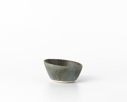 Handcrafted small concrete dessert bowl with greenish-gray glaze on white background