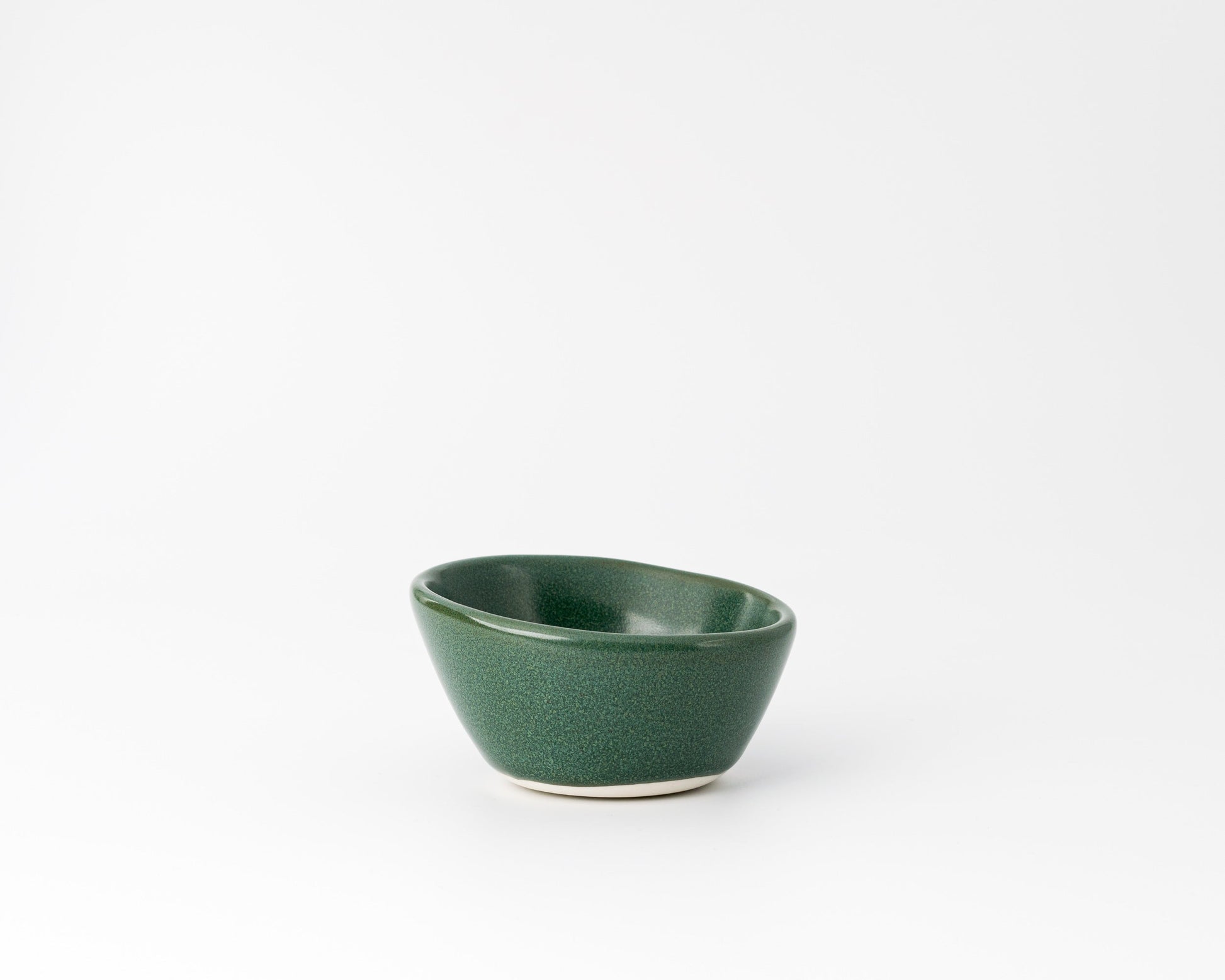 Handcrafted dark green ceramic dessert bowl with smooth asymmetric design on white background