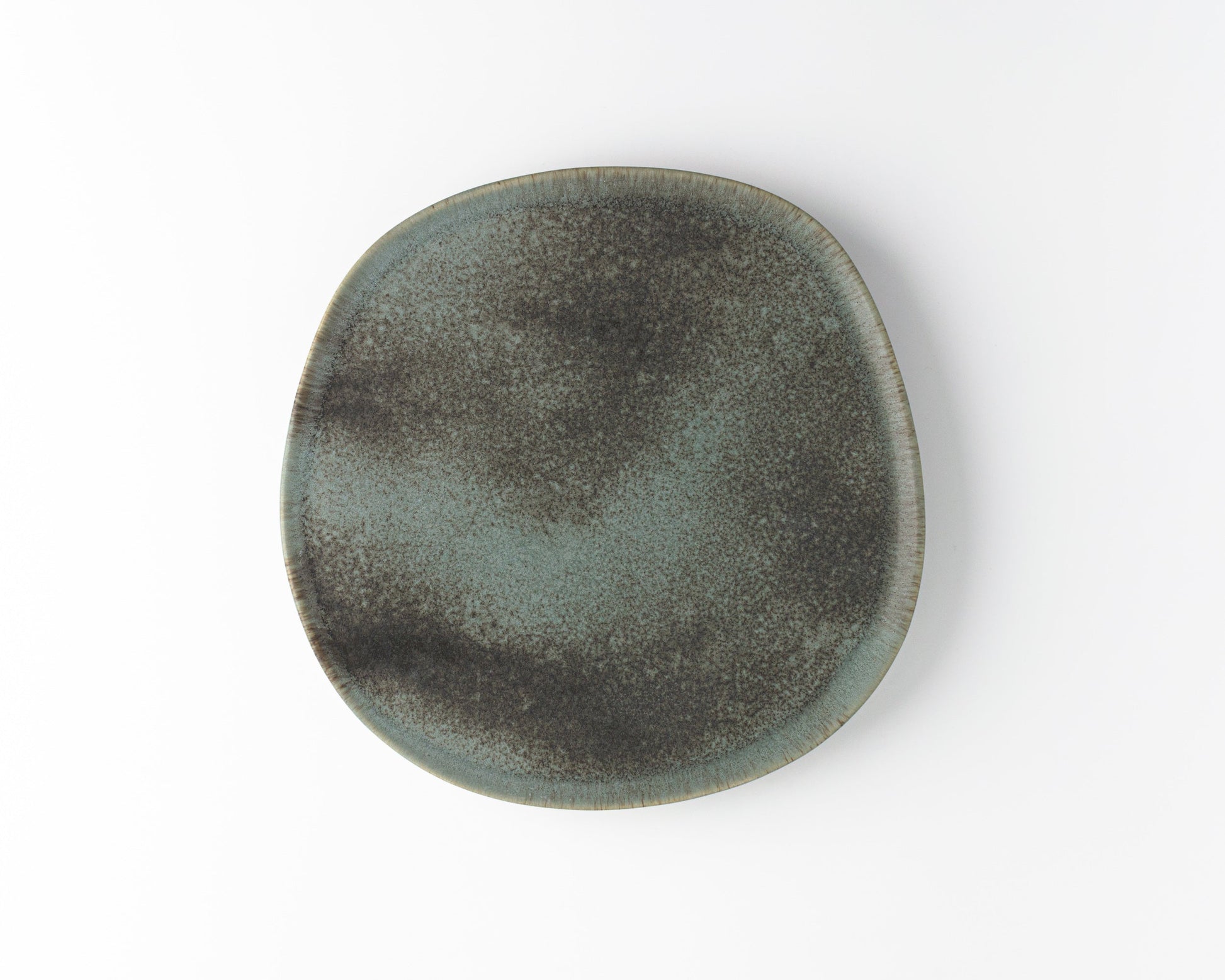 Round ceramic dinner plate with speckled gray and black glaze on white background