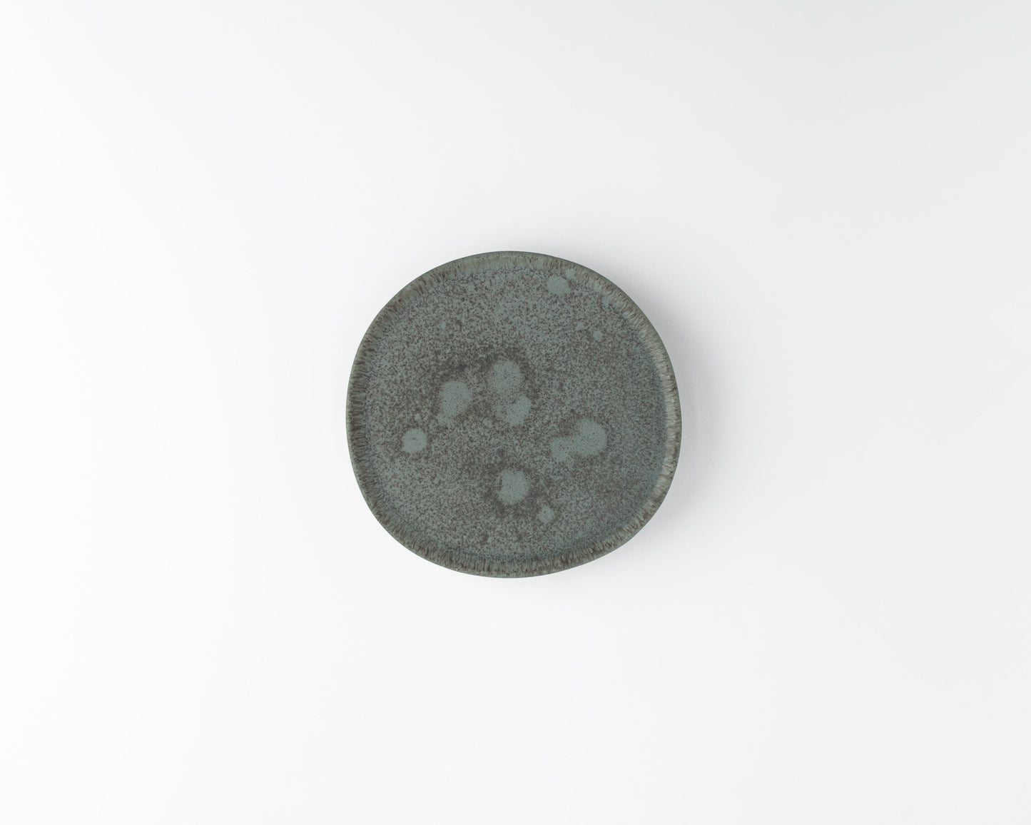 Top view of a small round gray ceramic plate with textured speckled surface on white background