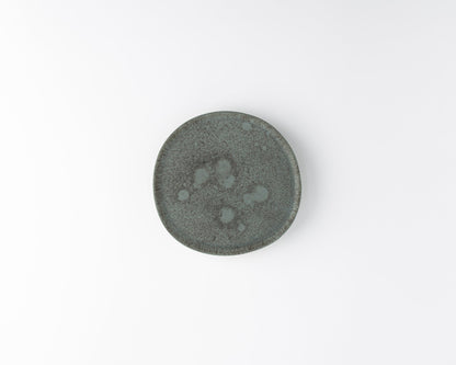Top view of a small round gray ceramic plate with textured speckled surface on white background