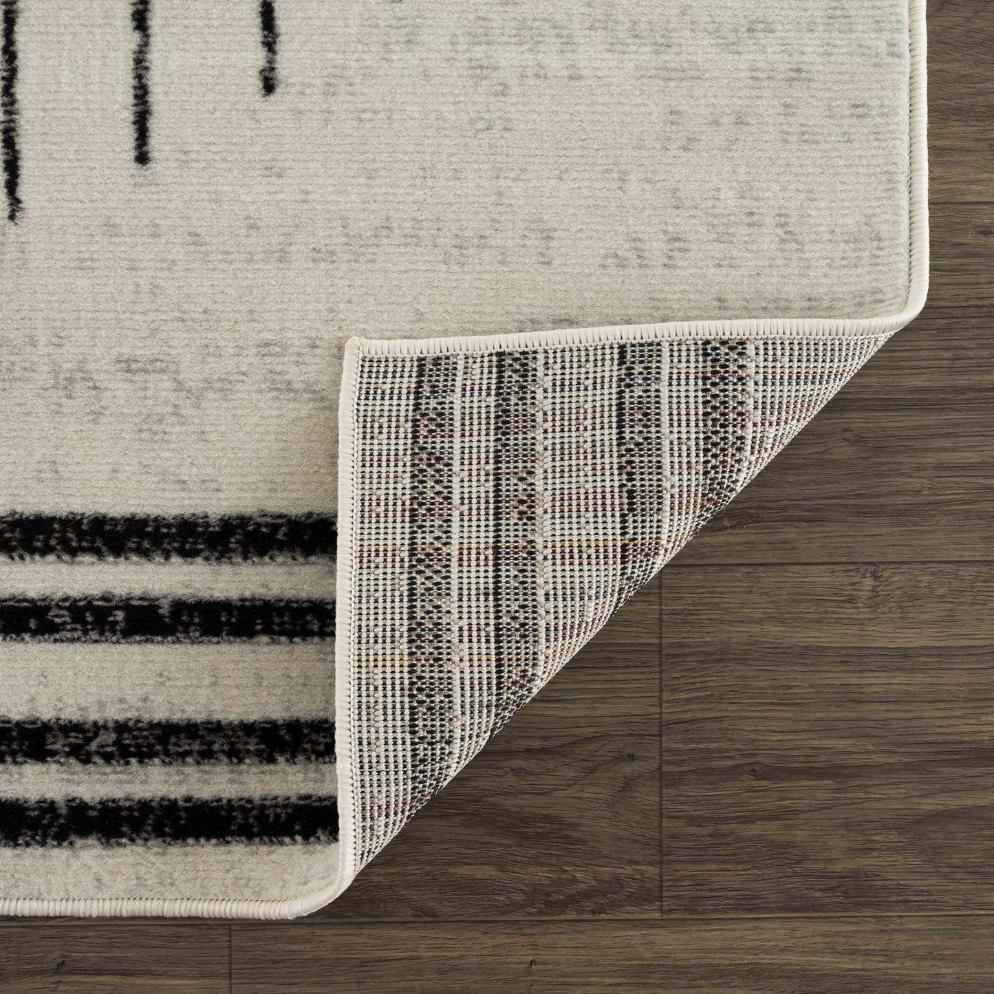 Close-up of the Angus Abstract Black and White Area Rug, showcasing its texture, binding, and polypropylene backing.