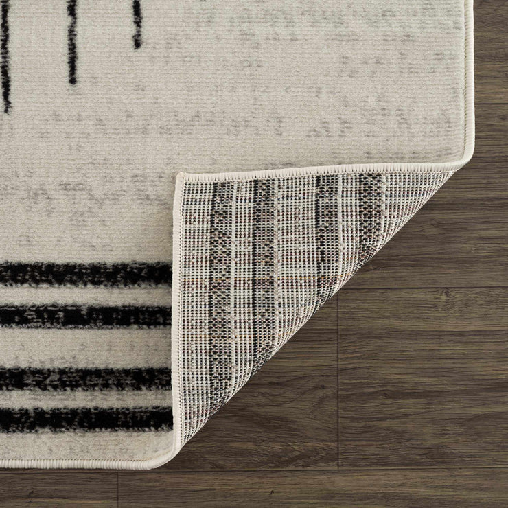 Close-up of the Angus Abstract Black and White Area Rug, showcasing its texture, binding, and polypropylene backing.