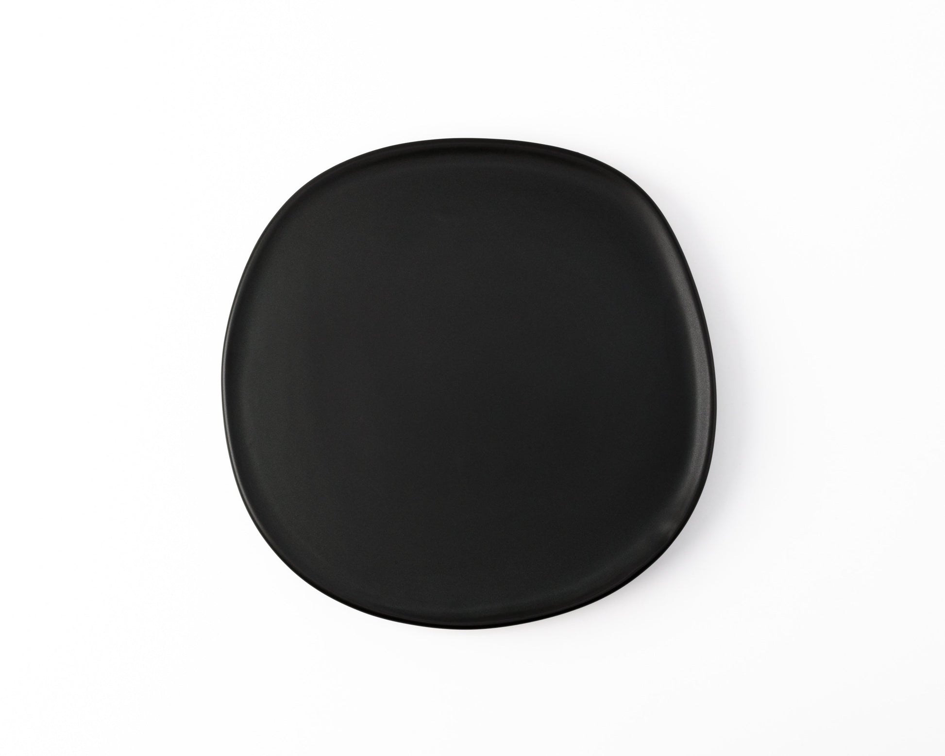 Black matte square ceramic plate with rounded edges on white background