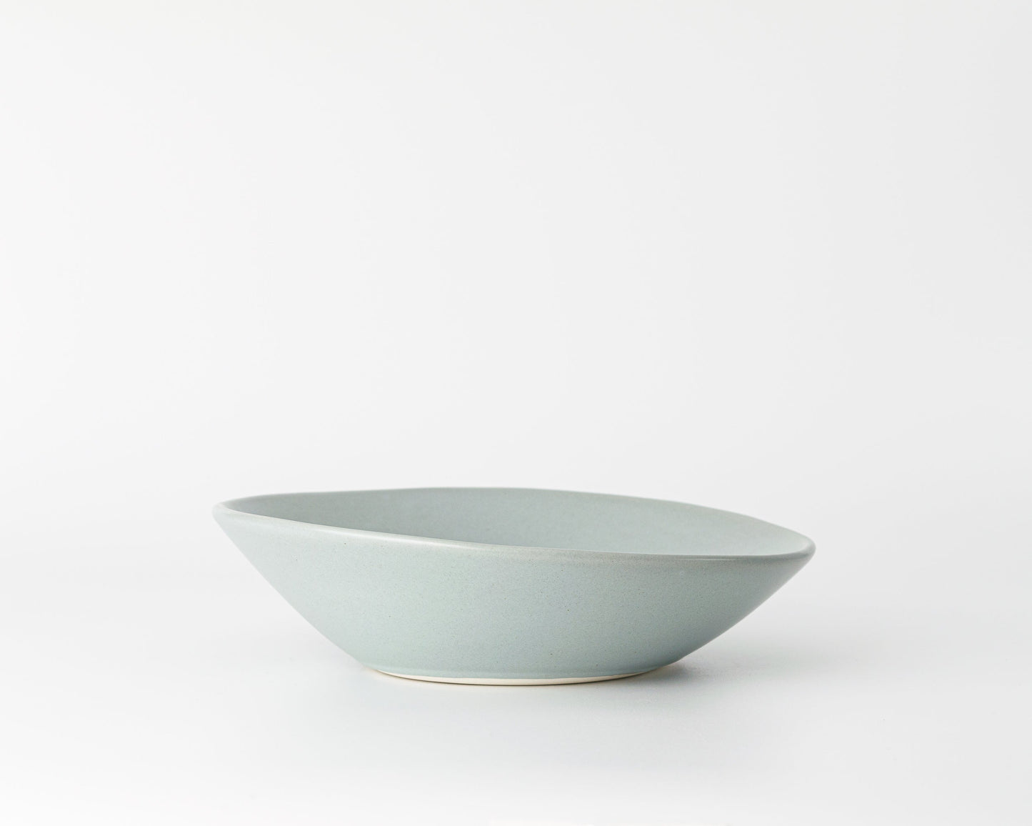 Light gray ceramic soup bowl with an angled rim on a white background