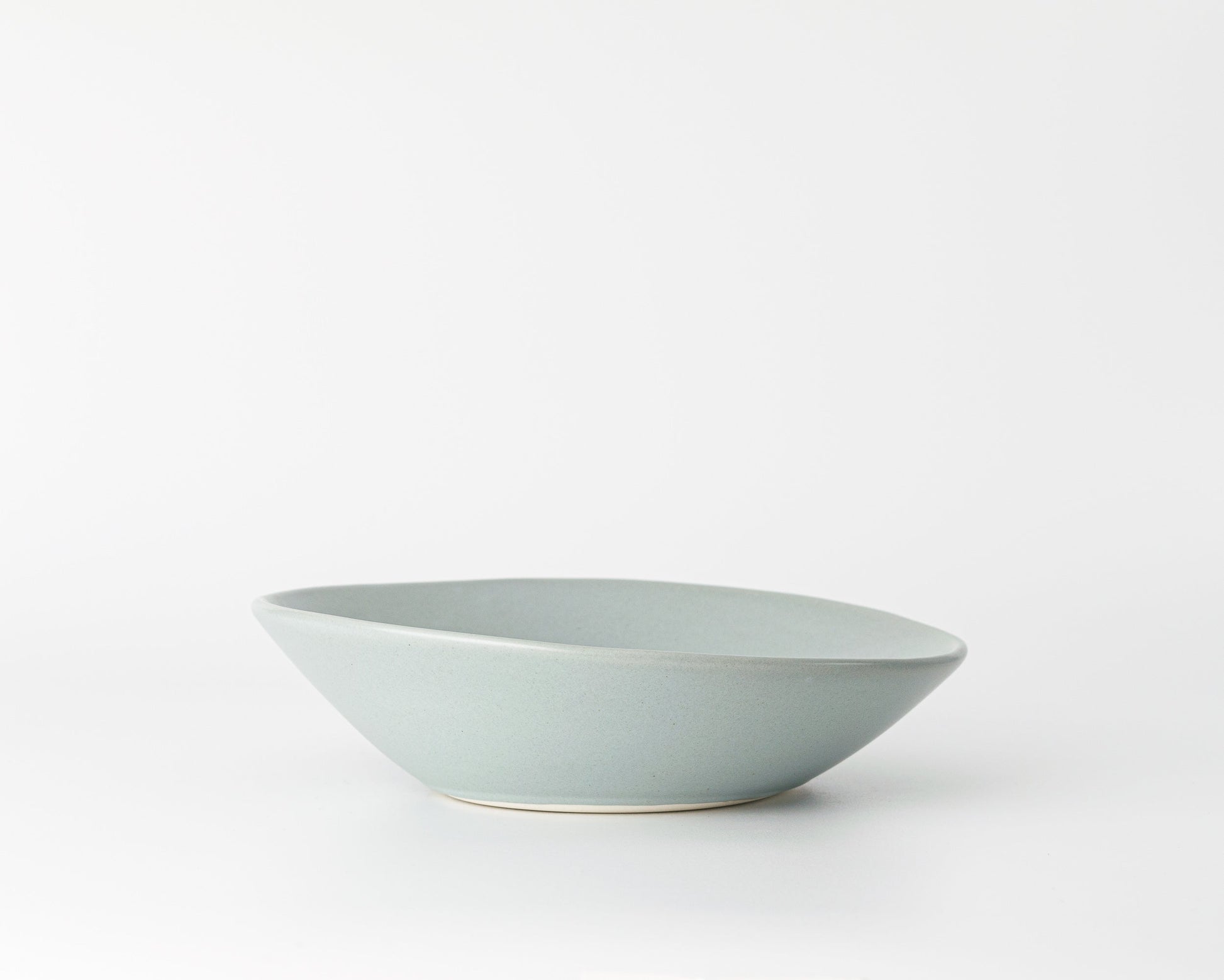 Light gray ceramic soup bowl with an angled rim on a white background