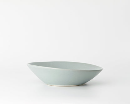 Light gray ceramic soup bowl with an angled rim on a white background