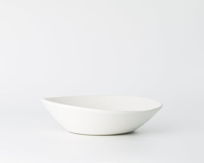 Minimalist white ceramic soup bowl on a plain white background