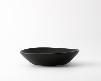 Black ceramic soup bowl with a smooth matte finish on a white background
