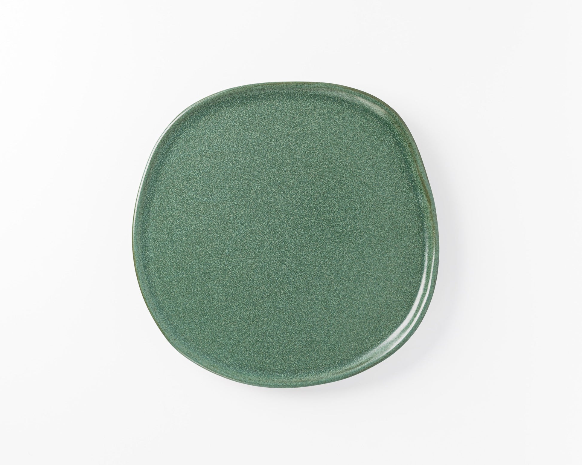 Green ceramic irregular round dinner plate on white background
