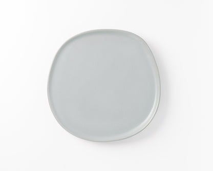 Minimalist light gray ceramic plate with rounded square shape on white background