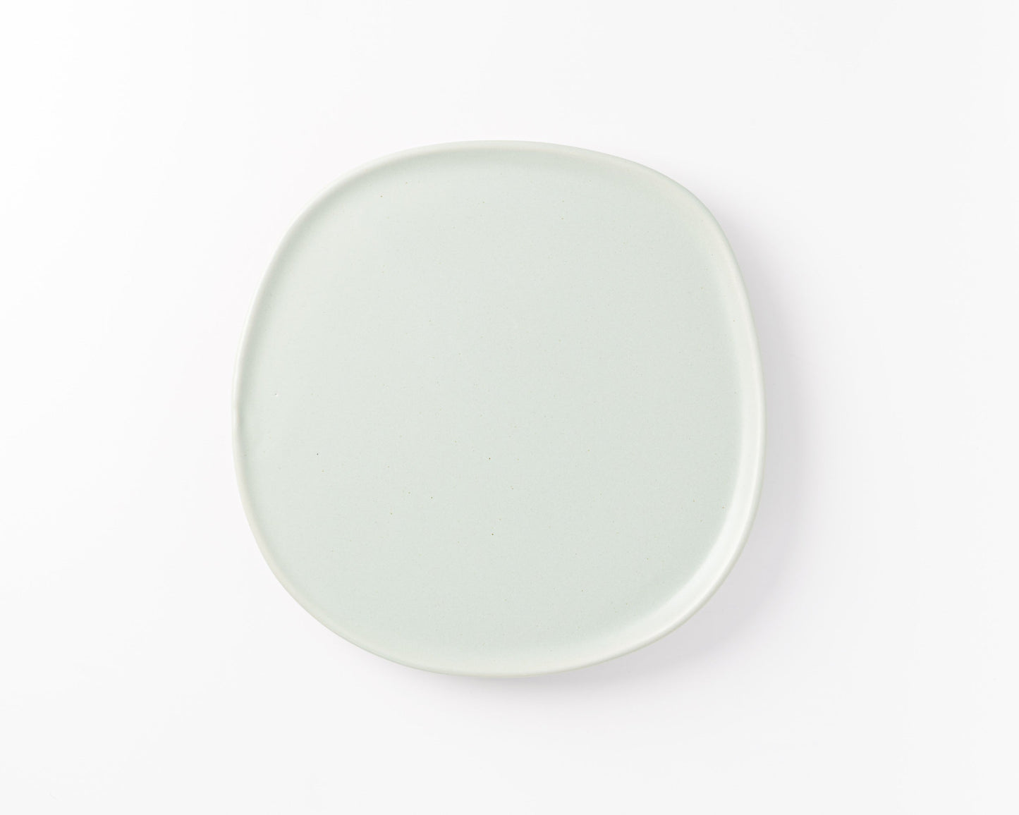 Minimalist square light gray ceramic plate with rounded edges on white background