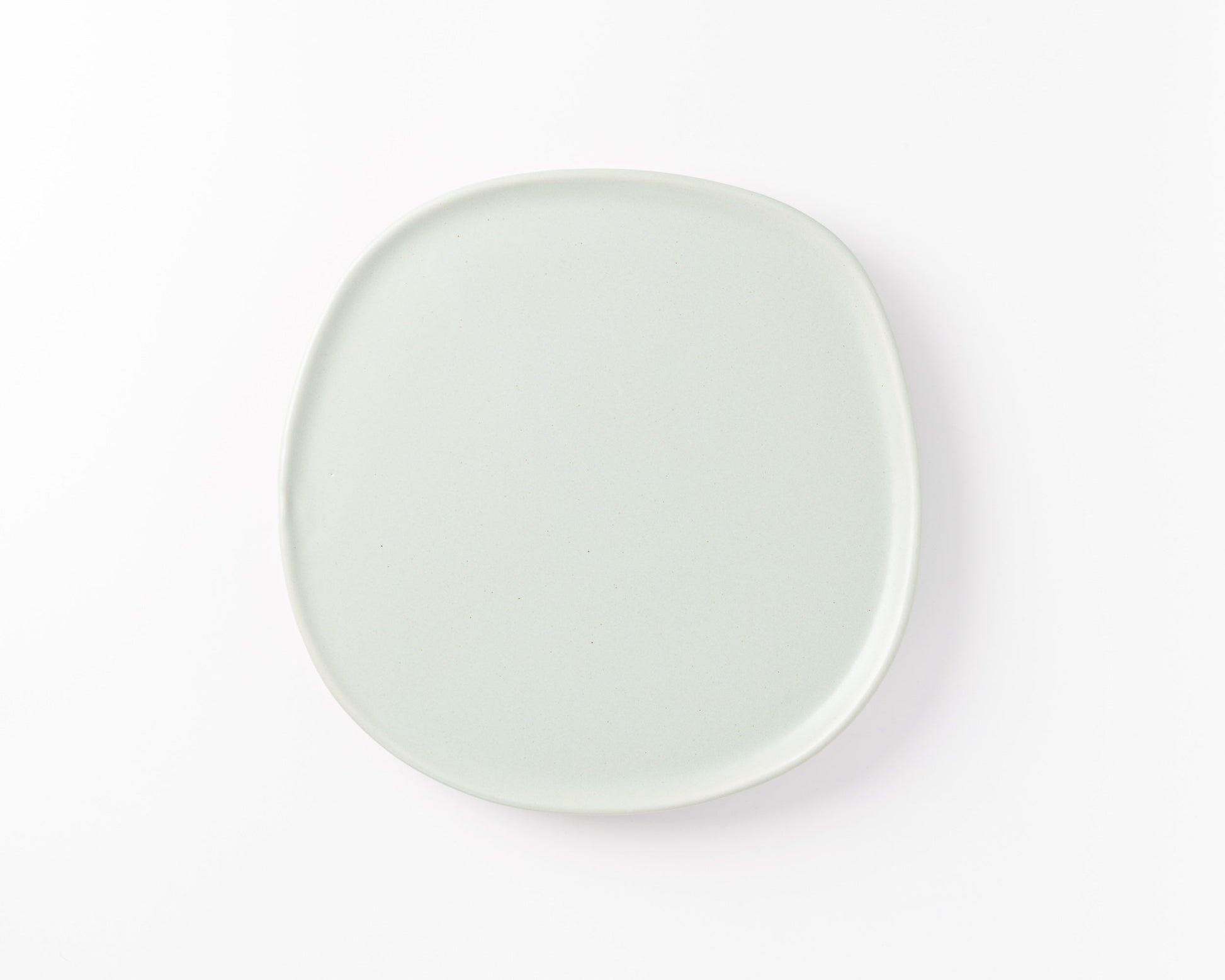 Minimalist square light gray ceramic plate with rounded edges on white background
