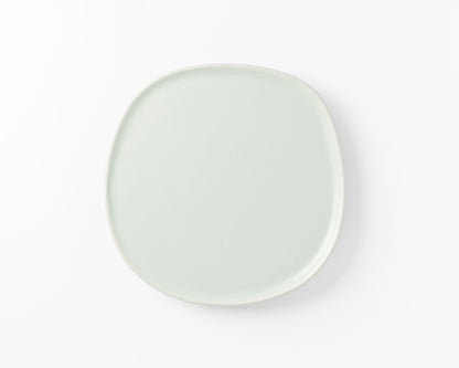 Minimalist square light gray ceramic plate with rounded edges on white background
