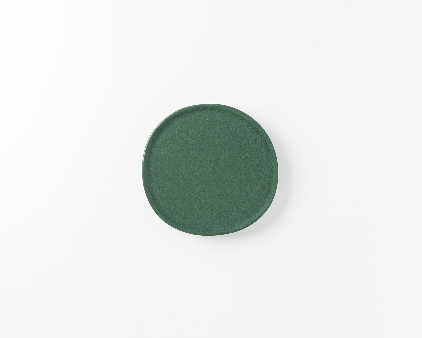 Simple green ceramic plate on white background, modern minimalist tableware