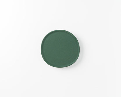 Simple green ceramic plate on white background, modern minimalist tableware